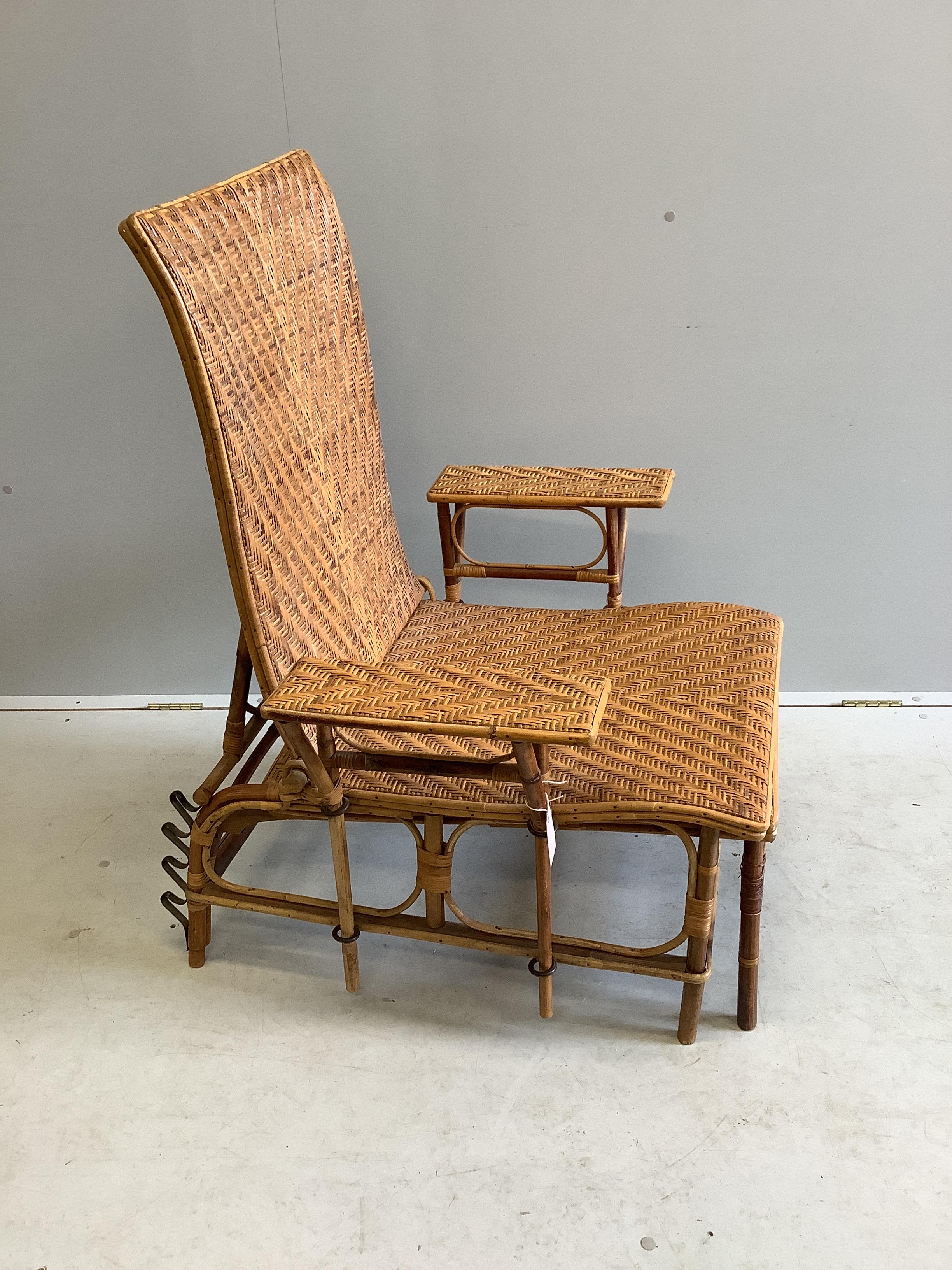 An early 20th century French caned bamboo reclining garden chair, with integral footrest, width 75cm, height 92cm